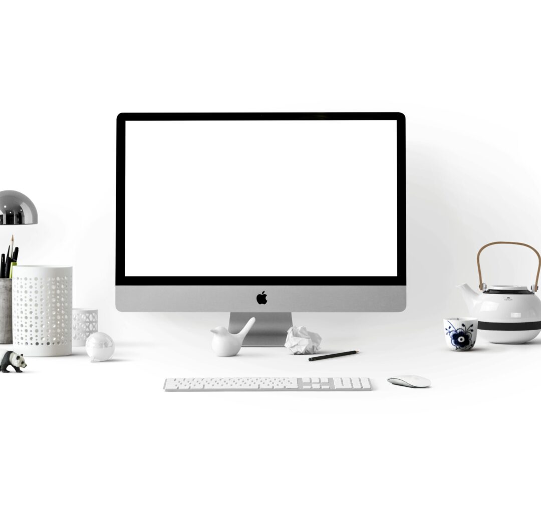 Minimalistic office desk setup with an iMac, accessories, and decorations against a white background.